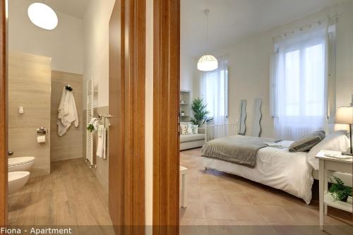 a bedroom with a bed and a bathroom at Mamo Florence - Fiesolana Apartments in Florence