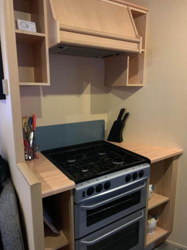 a kitchen with a stove and a counter top at Serenity Place Caravan 2 Double Beds With Varanda in Skegness