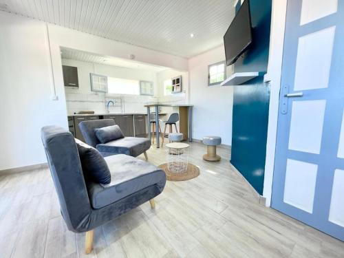 ein Wohnzimmer mit einer Couch und einem Sessel in der Unterkunft Appartement cosy à Case-Pilote avec terrasse - 65 m² in Case-Pilote