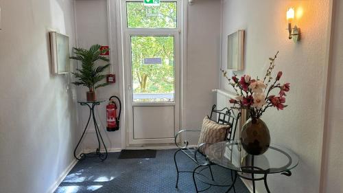 a hallway with a table and a vase of flowers at Goethe Hotel in Bad Pyrmont