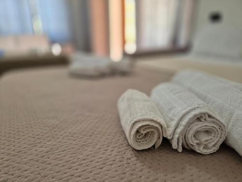 three rolled up towels sitting on a bed at RELAX MAREMONTI Ampia e Panoramica con spaziosa Veranda Attrezzata in Capoterra