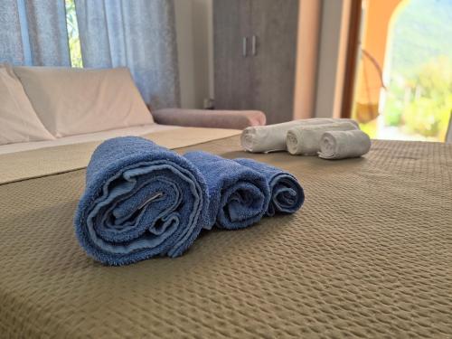 a bed with towels and two rolled up towels on it at RELAX MAREMONTI Ampia e Panoramica con spaziosa Veranda Attrezzata in Capoterra
