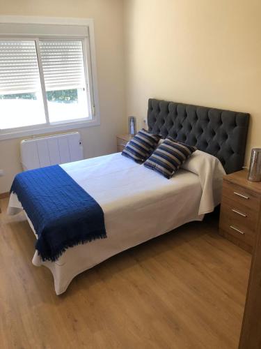 a bedroom with a large bed with a blue blanket at Casa Aricel VT in Chantada