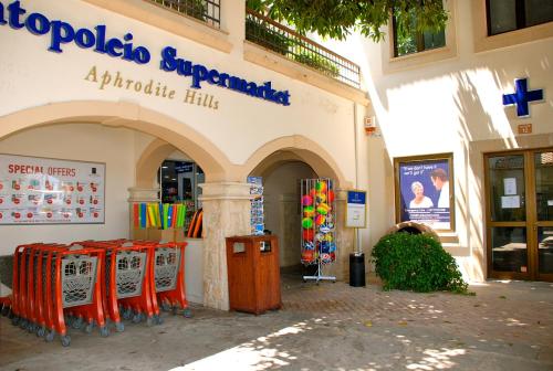 a store with a sign on the side of a building at Charming Apartment PZ12 - Lefkara, Aphrodite Hills in Kouklia