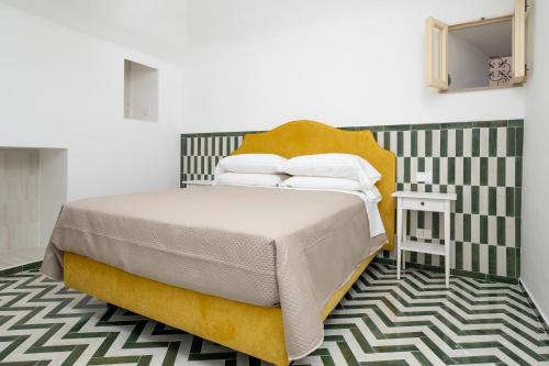 ein Schlafzimmer mit einem Bett mit einem gelben Kopfteil in der Unterkunft Honey Home - De Vivo Realty Positano in Positano