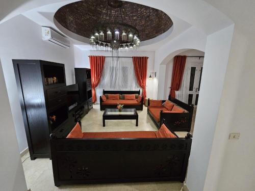 a living room with a couch and a chandelier at Private Villa Heated Pool & Enclosed Garden in Hurghada