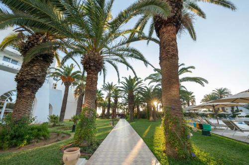 a row of palm trees in a park at Hotel Marhaba Beach in Sousse