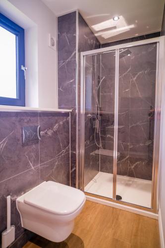 a bathroom with a toilet and a shower at Lowwood Lodges in Houston
