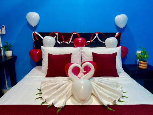 a bed with red and white balloons and two hearts at Hema Holiday Villa in Trincomalee
