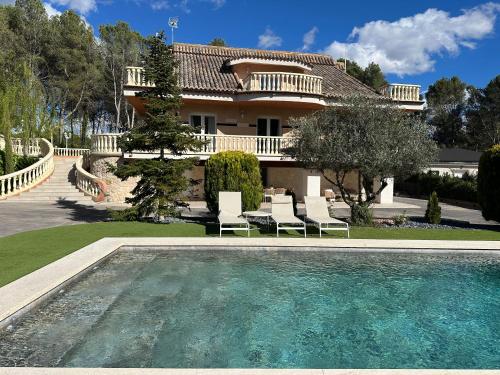 a house with a swimming pool in front of a house at Carrasca 8 paddle & pool in Alcoy