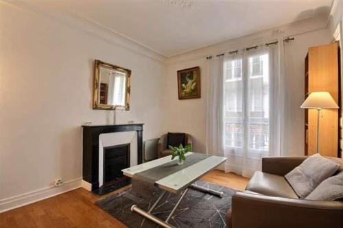 un salon avec un canapé et une cheminée dans l'établissement Appartement champs Elysée, à Paris