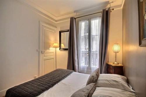 - une chambre avec un lit en face d'une fenêtre dans l'établissement Appartement champs Elysée, à Paris