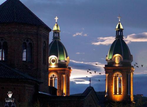 two towers of a church with birds flying between them at Hotel Pueblo Dorado Sesquilé in Sesquilé