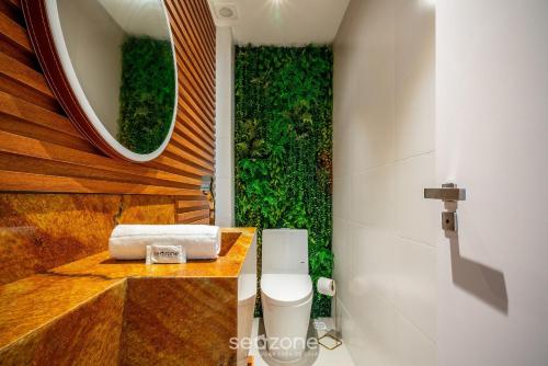 a bathroom with a sink and a toilet and a mirror at Apto moderno c/vista mar em Porto Belo SC MRE801 in Porto Belo