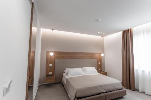 a bedroom with a bed and a large mirror at Alexander House Hotel in San Ferdinando