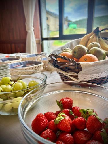 Una mesa cubierta con cuencos de fresas y frutas. en Coronel Somiedo by Unusual Hotels, en El Puerto de Somiedo