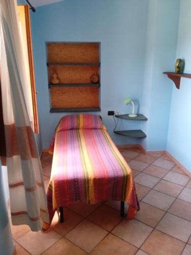 a room with a bench with a colorful blanket on it at Appartamento Pisturri in Magomadas