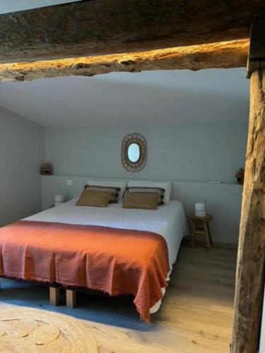 une chambre avec un grand lit avec une couverture orange dans l'établissement L'Echauguette, villa de luxe avec piscine, à Carcassonne