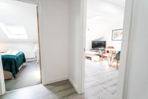 a white room with a bed and a dining room at 3 Bedroom Apartment, Walking Distance to Centre & Amazing Food at your door step in Cardiff