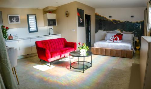 a living room with a red chair and a bed at Dolce Vita, Spa, Cagnes Sur Mer in Cagnes-sur-Mer