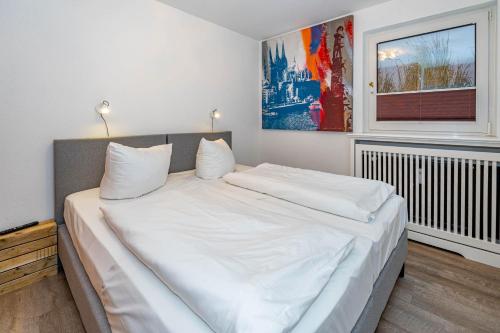 een groot wit bed in een kamer met een raam bij Constantin in Tinnum