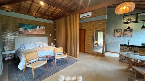 a bedroom with a bed and a table and chairs at Villa Zarandi - Luxo e conforto que você procura! in Petrópolis