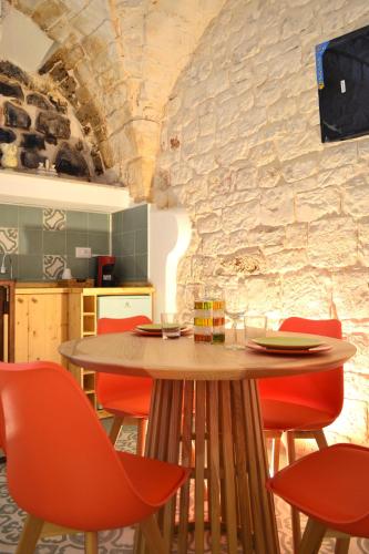 a dining room with a table and red chairs at Casa Philos in Ceglie Messapica