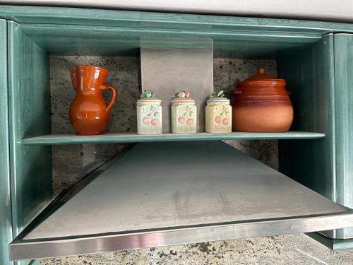 a shelf with three vases and three jars on it at Casa Independiente Bella Vista in Moaña