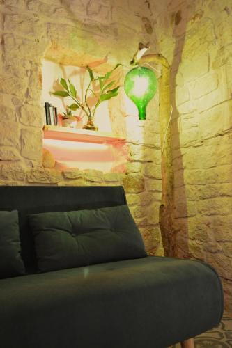 a room with a couch and a green lamp at Casa Philos in Ceglie Messapica
