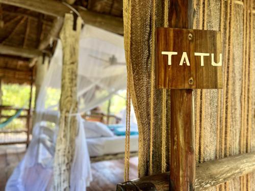 a sign that says talu on the side of a bed at Chole Mjini Treehouses Lodge in Utende