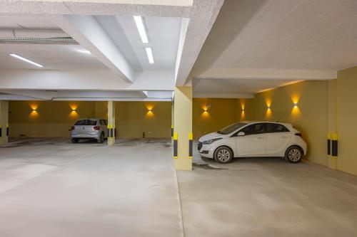 two cars parked in an empty parking garage at Zur Suítes in Campos do Jordão