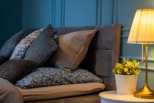 a pile of pillows on a couch next to a lamp at Resort Červený dvůr in Rapotín