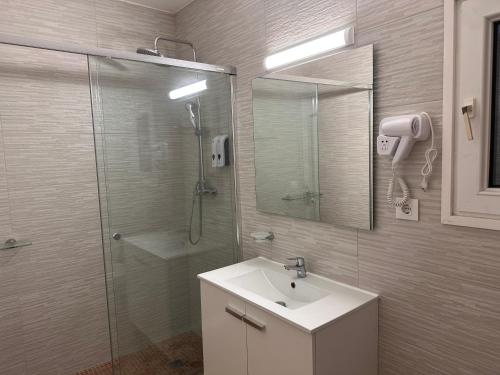 a bathroom with a sink and a shower with a mirror at Villa IRI Habitación N 2 con un baño compartido , balcón in Pineda de Mar
