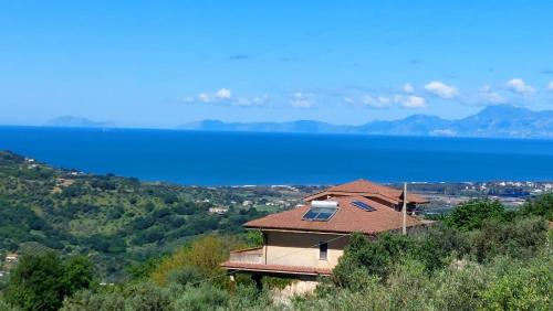a house on a hill with a view of the water at Villa Finocchito - The sound of silence in Ogliastro Cilento