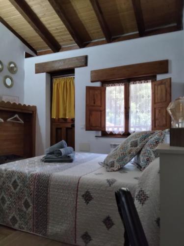a bedroom with a bed and two windows at Casa Marcelo in Proaza