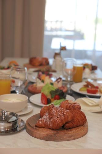 a table with plates of food and croissants on it at Gewan Palace New Alamein in El Alamein