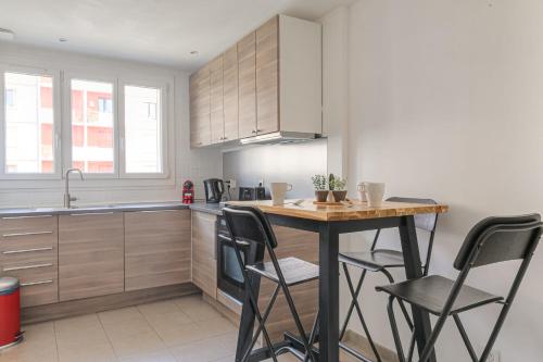 une cuisine avec une table et quelques chaises dans l'établissement Charmant et Chaleureux proche métro Gratte-Ciel, à Villeurbanne