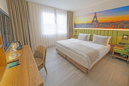 a bedroom with a bed and a view of the eiffel tower at Friends Hotel Düsseldorf-Airport Ratingen in Ratingen