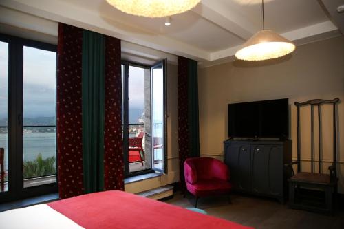 a bedroom with a bed and a tv and windows at Hotel Retro in Batumi
