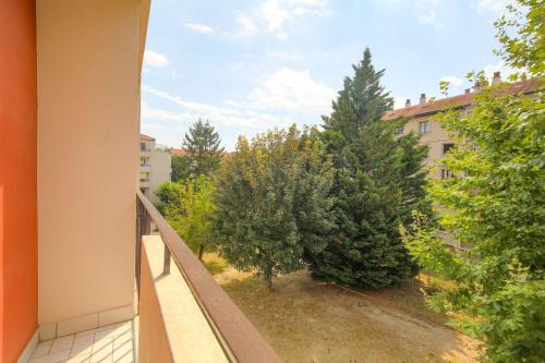 - un balcon avec vue sur un bâtiment arboré dans l'établissement Charmant et Chaleureux proche métro Gratte-Ciel, à Villeurbanne
