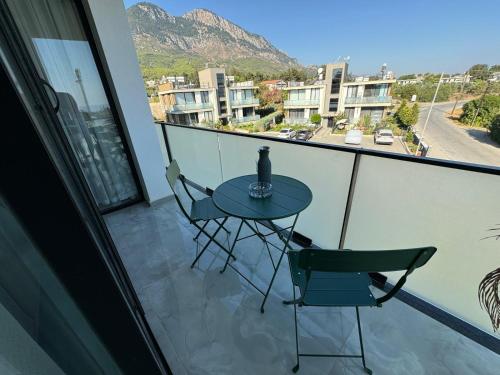 a table and two chairs on a balcony with a view at Penthouse in Lapta, a Cozy Coastal Retreat in Lapithos