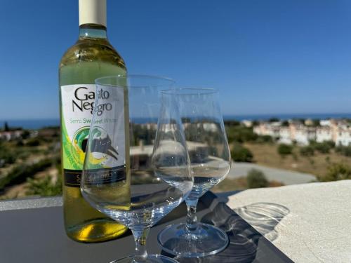 two wine glasses sitting next to a bottle of wine at Penthouse in Lapta, a Cozy Coastal Retreat in Lapithos
