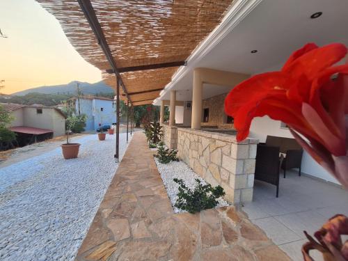 un edificio con un fiore rosso sul lato di Rousis's Manor House a Párga