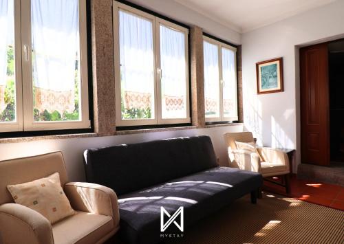 a living room with a couch and some windows at MyStay - Casa da Portaria in Tarouca