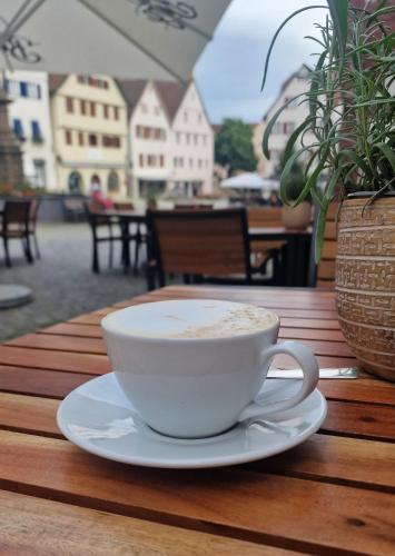 a cup of coffee sitting on a wooden table at Boutique- und Businesshotel Herrenküferei in Markgröningen