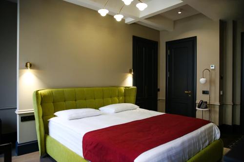 a bedroom with a large bed with a green headboard at Hotel Retro in Batumi