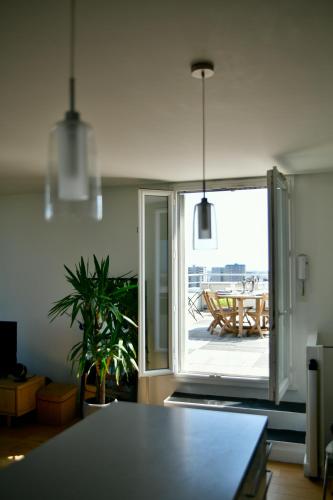 - un salon avec une table et une vue sur un patio dans l'établissement Duplex rooftop vue Tour Eiffel, à Bagnolet