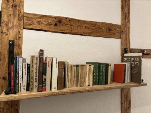 a wooden shelf with books on a wall at Lindenhof Michaelis - Urlaub auf dem historischen Gutshof in Liebstadt