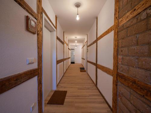 a hallway with wooden floors and a brick wall at Lindenhof Michaelis - Urlaub auf dem historischen Gutshof in Liebstadt