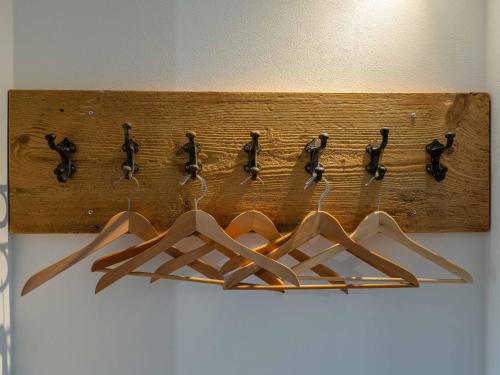 a wooden rack with four hangers on a wall at Lindenhof Michaelis - Urlaub auf dem historischen Gutshof in Liebstadt
